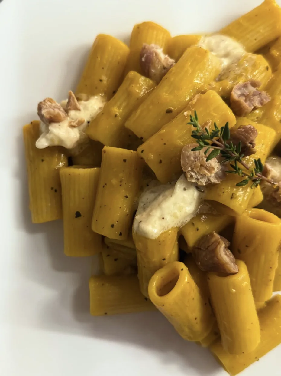 Rigatoni con crema gialla, stracciatella e granella